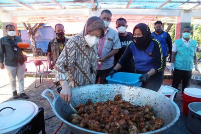 Mensos Tri Rismaharini ikut memasak untuk para pejuang Covid-19 di Dapur Umum di area halaman Convention Hall Surabaya, Jawa Timur, Senin (5/7/2021).