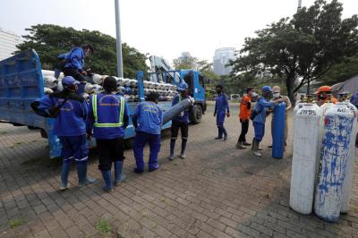 Sejumlah petugas menurunkan tabung berisi oksigen dari truk di Posko Darurat Oksigen Rescue di kawasan Monumen Nasional, Jakarta, Senin (5/7/2021).