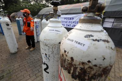 Sejumlah petugas menurunkan tabung berisi oksigen dari truk di Posko Darurat Oksigen Rescue di kawasan Monumen Nasional, Jakarta, Senin (5/7/2021).