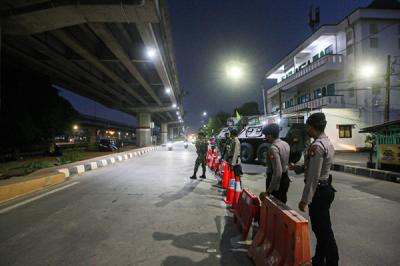 Petugas berjaga di barikade penyekatan PPKM Darurat di Pos Lampiri Kalimalang, Jakarta Timur, Senin (5/7/2021).