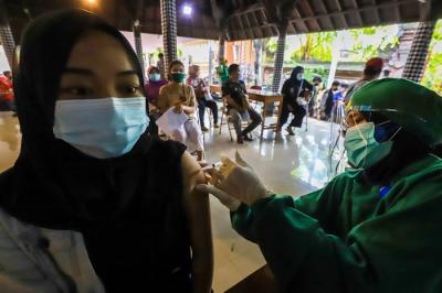 Warga saat mengikuti vaksinasi massal Covid-19 di rumah ibadah Pure Candra Prabha, Jakarta Barat, Senin (5/7/2021).