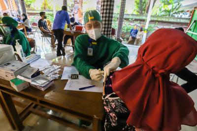 Warga saat mengikuti vaksinasi massal Covid-19 di rumah ibadah Pure Candra Prabha, Jakarta Barat, Senin (5/7/2021).