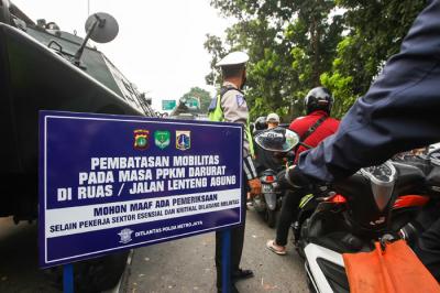 Petugas Brimob saat melakukan pemeriksaan warga yang melewati pos penyekatan PPKM Darurat di Lenteng Agung, Jakarta Selatan, Selasa (6/7/2021).