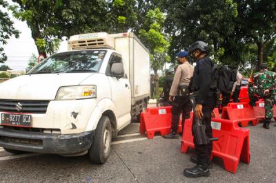 Petugas Brimob saat melakukan pemeriksaan warga yang melewati pos penyekatan PPKM Darurat di Lenteng Agung, Jakarta Selatan, Selasa (6/7/2021).