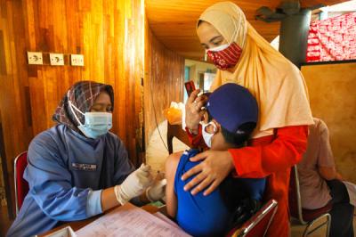 Petugas saat memberikan dosis vaksin untuk anak berusia 12 - 17 tahun di Setu Babakan, Jagakarsa, Jakarta Selatan, Selasa (6/7/2021).