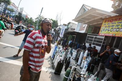 Karyawan toko saat memberikan arahan kepada warga yang akan mengisi ulang tabung oksigen di kawasan Manggarai, Jakarta Selatan, Selasa (6/7/2021).