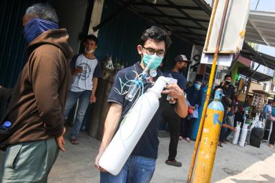 Karyawan toko saat memberikan arahan kepada warga yang akan mengisi ulang tabung oksigen di kawasan Manggarai, Jakarta Selatan, Selasa (6/7/2021).