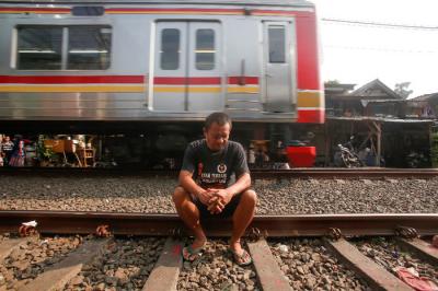 Warga berjemur di dekat jalur kereta api di kawasan Pejompongan, Jakarta Pusat, Selasa (6/7/2021).