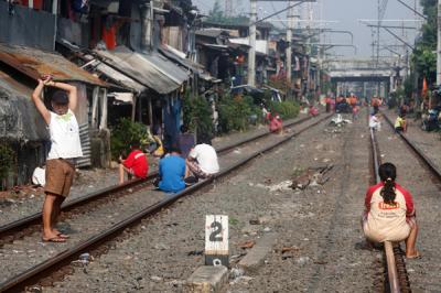 Warga berjemur di dekat jalur kereta api di kawasan Pejompongan, Jakarta Pusat, Selasa (6/7/2021).