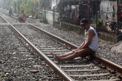 Warga berjemur di dekat jalur kereta api di kawasan Pejompongan, Jakarta Pusat, Selasa (6/7/2021).