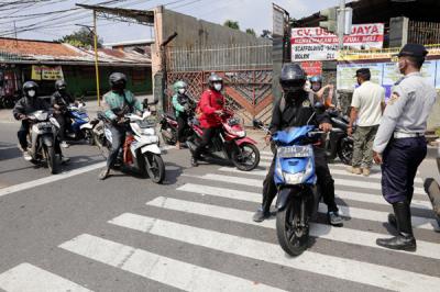 Petugas gabungan memutar arah kendaraan saat penyekatan di ruas Jalan Raya Bogor, Jakarta, Rabu (7/7/2021).