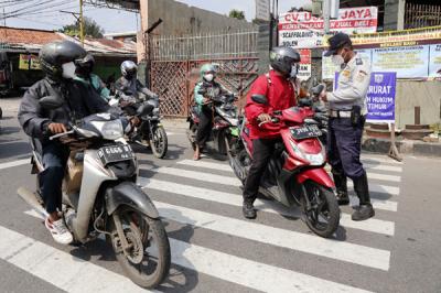 Petugas gabungan memutar arah kendaraan saat penyekatan di ruas Jalan Raya Bogor, Jakarta, Rabu (7/7/2021).