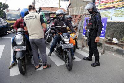 Petugas gabungan memutar arah kendaraan saat penyekatan di ruas Jalan Raya Bogor, Jakarta, Rabu (7/7/2021).
