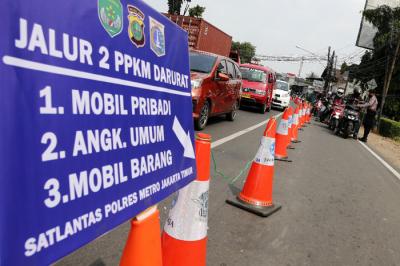 Petugas gabungan memutar arah kendaraan saat penyekatan di ruas Jalan Raya Bogor, Jakarta, Rabu (7/7/2021).