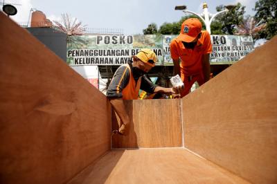 Petugas PPSU menyelesaikan pengerjaan peti jenazah untuk pasien Covid-19 di Kantor Kelurahan Kayu Putih, Jakarta, Selasa (6/7/2021).