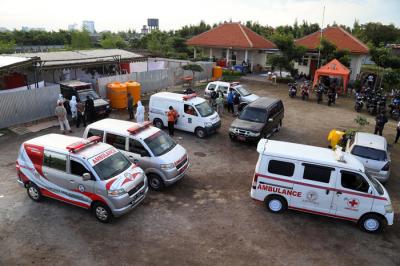 Petugas mengangkat peti jenazah untuk dilakukan perawatan sebelum di makamkan di tempat pemulasaraan darurat Keputih Surabaya, Jawa Timur, Kamis (8/7/2021).