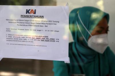 Penumpang Kereta Api duduk diantara bangku kosong di Stasiun Gubeng Surabaya, Jawa Timur, Kamis (8/7/2021).