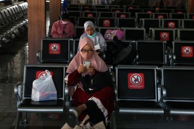 Penumpang Kereta Api duduk diantara bangku kosong di Stasiun Gubeng Surabaya, Jawa Timur, Kamis (8/7/2021).