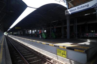Penumpang Kereta Api duduk diantara bangku kosong di Stasiun Gubeng Surabaya, Jawa Timur, Kamis (8/7/2021).