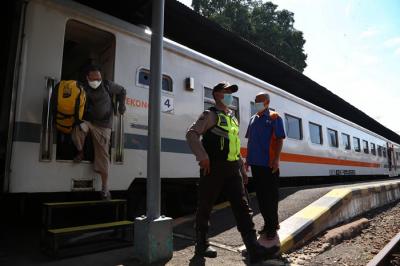 Penumpang Kereta Api duduk diantara bangku kosong di Stasiun Gubeng Surabaya, Jawa Timur, Kamis (8/7/2021).