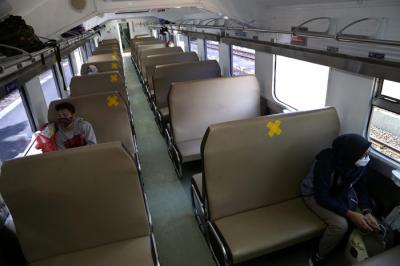 Penumpang Kereta Api duduk diantara bangku kosong di Stasiun Gubeng Surabaya, Jawa Timur, Kamis (8/7/2021).