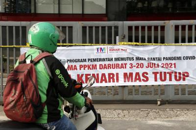 Pejalan kaki melintas di depan gerbang masuk Plaza Kenari Mas, Jakarta Pusat, Kamis (8/7/2021).