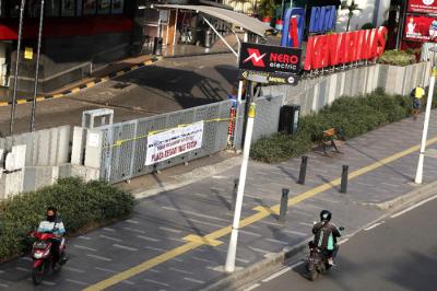 Pejalan kaki melintas di depan gerbang masuk Plaza Kenari Mas, Jakarta Pusat, Kamis (8/7/2021).