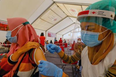 Petugas Palang Merah Indonesia menyuntikan vaksin Covid-19 kepada warga saat vaksinasi massal di Gudang Darurat Nasional, Jakarta Selatan, Jumat (9/7/2021).