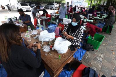 Sejumlah penjahit menyelesaikan pembuatan masker di Balai Kota Surabaya, Jawa Timur, Jumat (9/7/2021).