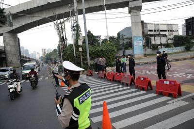 Petugas kepolisian memeriksa pengendara motor di Jalan Fatmawati yang ditutup di Jakarta, Sabtu (10/7/2021).