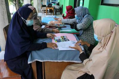 Orang tua calon murid mengembalikan formulir pendaftaran sekolah di SMK Syahid, Cilincing ,Jakarta, Sabtu (10/7/2021).