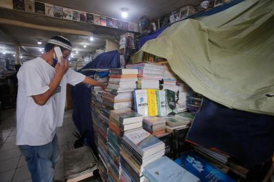 Pedagang menata buku di salah satu kios buku di kawasan Kwitang, Jakarta Pusat, Minggu (11/7/2021).