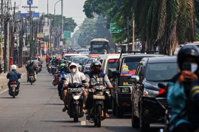 Petugas memeriksa KTP warga yang ingin melewati penyekatan di Jalan Molek, Pondok Gede, Kota Bekasi, Jawa Barat, Minggu (11/7/2021).