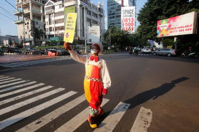 Angggota Komunitas Aku Badut Indonesia (ABI) melakukan aksi kampanye untuk menggunakan masker di Kawasan Fatmawati, Jakarta Selatan, Senin (12/7/2021).