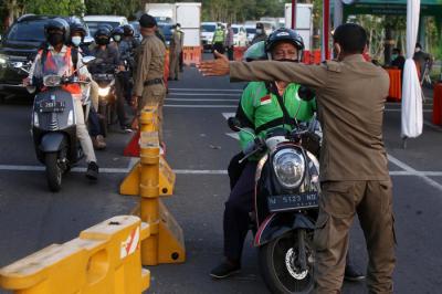 Petugas mengarahkan pengendara untuk putar balik saat akan masuk kota Surabaya melalui akses masuk dari Surabaya Timur di Jawa Timur, Senin (12/7/2021).
