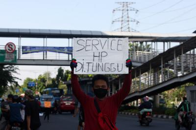 Tukang service Handphone menawarkan jasanya dipinggir jalan di kawasan Cililitan, Jakarta Timur, Senin (12/7/2021).