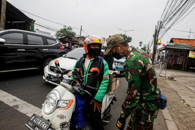 Warga saat menunjukan Surat Tanda Registrasi Pegawai (STRP) di penyekatan Jalan Raya Bogor, Jakarta Timur, Selasa (13/7/2021).
