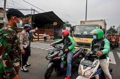 Warga saat menunjukan Surat Tanda Registrasi Pegawai (STRP) di penyekatan Jalan Raya Bogor, Jakarta Timur, Selasa (13/7/2021).