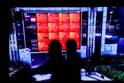 Pengendara saat melintas dengan berlatar belakang tampilan iklan videotron di gedung Bursa Efek Indonesia, Jakarta, Rabu (14/7/2021).