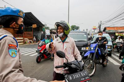 Aparat kepolisian memerksa kelengkapan surat warga saat melintas di pos penyekatan PPKM Darurat Jalan Raya Bogor, Jakarta Timur, Rabu (14/7/2021).