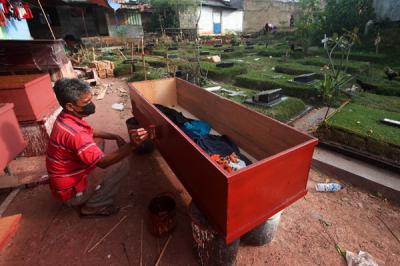 Pekerja menyelesaikan pembuatan peti jenazah untuk pasien Covid-19 di TPU Pondok Kelapa, Jakarta Timur, Rabu (14/7/2021).