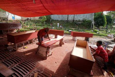 Pekerja menyelesaikan pembuatan peti jenazah untuk pasien Covid-19 di TPU Pondok Kelapa, Jakarta Timur, Rabu (14/7/2021).