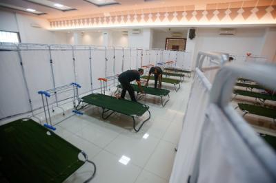 Petugas menyiapkan velbed untuk warga yang akan menjalani isolasi mandiri di Gelanggang Olahraga (GOR) Kecamatan Matraman, Jakarta Timur, Rabu (14/7/2021).
