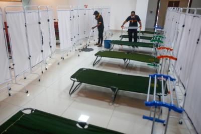 Petugas menyiapkan velbed untuk warga yang akan menjalani isolasi mandiri di Gelanggang Olahraga (GOR) Kecamatan Matraman, Jakarta Timur, Rabu (14/7/2021).