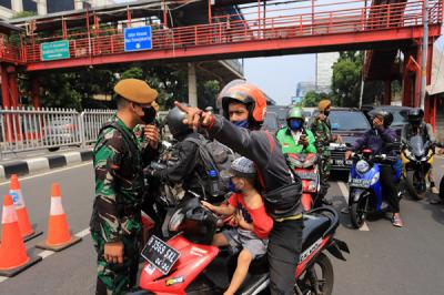Petugas kepolisian dibantu TNI dan Satpol PP mengalihkan arus kendaraan akibat diberlakukannya titik penyekatan di kawasan Mampang Prapatan, Kamis (15/7/2021).