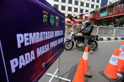 Petugas kepolisian dibantu TNI dan Satpol PP mengalihkan arus kendaraan akibat diberlakukannya titik penyekatan di kawasan Mampang Prapatan, Kamis (15/7/2021).