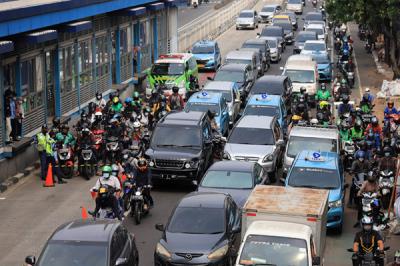 Petugas kepolisian dibantu TNI dan Satpol PP mengalihkan arus kendaraan akibat diberlakukannya titik penyekatan di kawasan Mampang Prapatan, Kamis (15/7/2021).