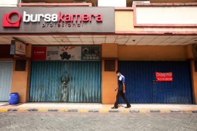 Pekerja berjalan di kawasan pertokoan yang tutup di ITC Fatmawati, Jakarta Selatan, Jumat (16/7/2021).