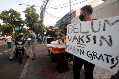 Barista membagikan makanan siap saji di depan Kopi Muja, Kebayoran Baru, Jakarta Selatan, Jumat (16/7/2021).