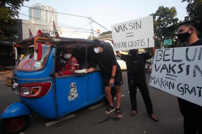 Barista membagikan makanan siap saji di depan Kopi Muja, Kebayoran Baru, Jakarta Selatan, Jumat (16/7/2021).